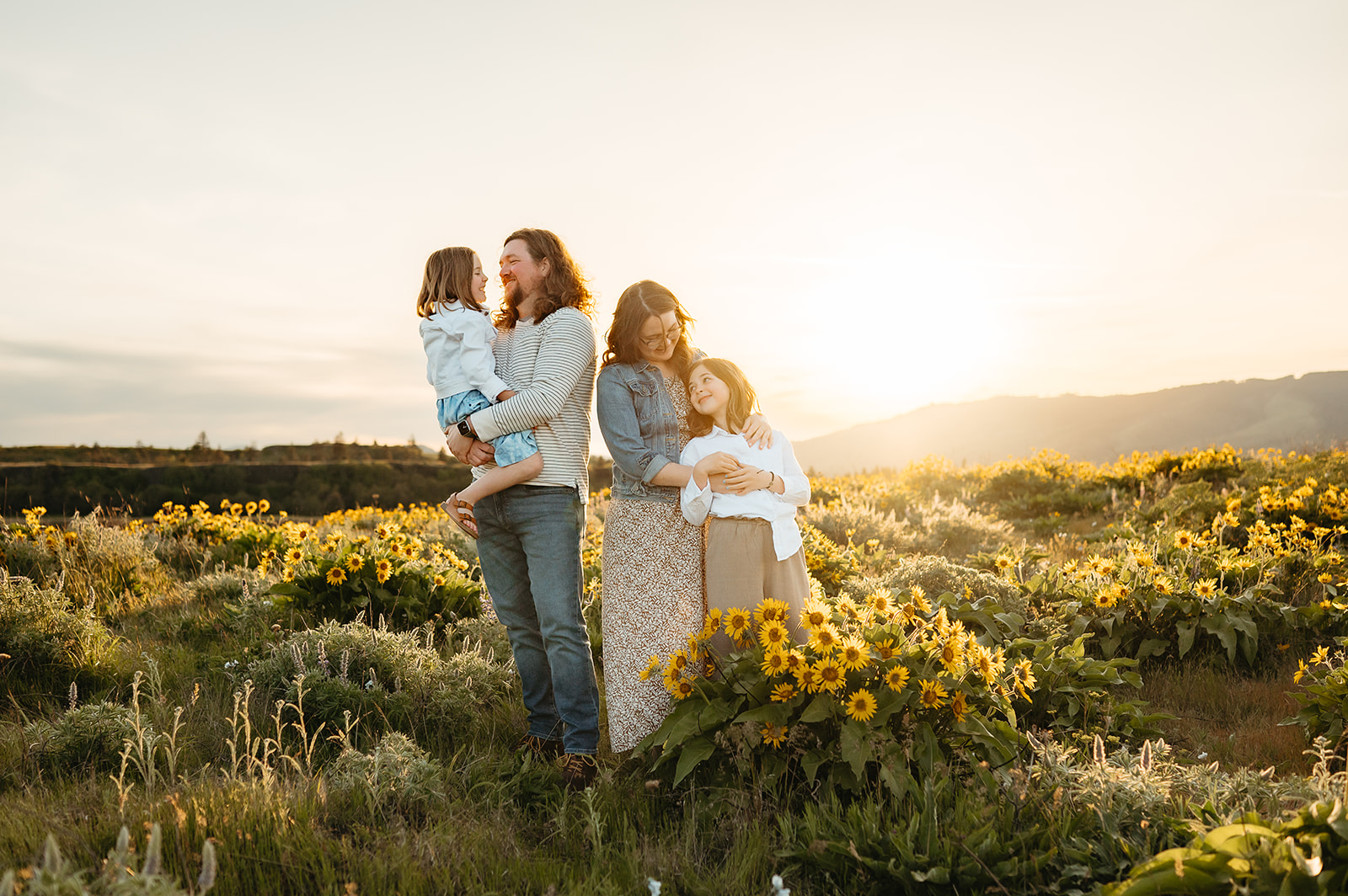Two children dancing and twirling in a sunlit field of wildflowers, with the golden hour light glowing behind them